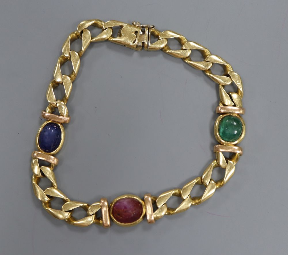 A modern 750 yellow metal and cabochon, ruby, sapphire and emerald set curblink bracelet,(stones worn, emerald chipped)